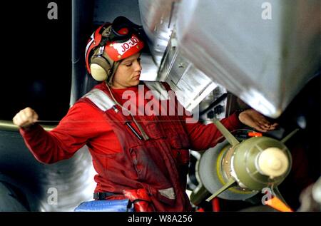 A U.S. Navy aviation ordnanceman applies the final wiring to a GBU-24 laser-guided bomb attached to an F-14 Tomcat on the flight deck of the USS Theodore Roosevelt (CVN 71) on May 4, 1999.  Roosevelt and its embarked Carrier Air Wing 8 are operating in the Adriatic Sea in support of NATO Operation Allied Force which is the air operation against targets in the Federal Republic of Yugoslavia. Stock Photo