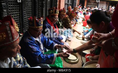 Lalitpur, Nepal. 08th Aug, 2019. Buddhists distribute offerings to priests during Pancha Dan festival in Lalitpur, Nepal. Pancha Dan is the festival of five summer gifts donating the five different things including rice grains, unhusked rice grains, salt, money and pulses. (Photo by Archana Shrestha/Pacific Press) Credit: Pacific Press Agency/Alamy Live News Stock Photo