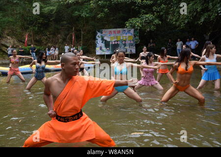 A Chinese Shaolin monk instructs female rafting lifeguard candidates to learn kungfu during a training session at the Gulongxia (Gulong Gorge) rafting Stock Photo