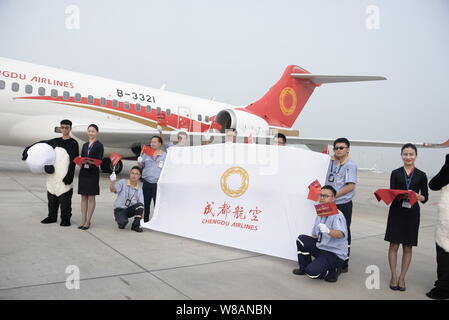 Chinese employees and air hostesses pose in front of a COMAC ARJ21 regional jet of Sichuan Airlines at the Chengdu Shuangliu International Airport in Stock Photo