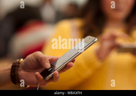 --FILE--A customer tries out an iPhone 6S Plus smartphone at an Apple Store in Guangzhou city, south China's Guangdong province, 28 February 2016.   A Stock Photo