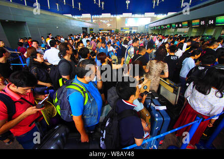 --FILE--A crowd of passengers queue up in front of counters of airlines after their flights were delayed or cancelled due to thunder storms at the Sha Stock Photo