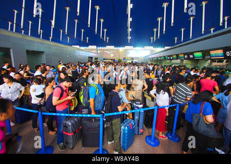 --FILE--A crowd of passengers queue up in front of counters of airlines after their flights were delayed or cancelled due to thunder storms at the Sha Stock Photo