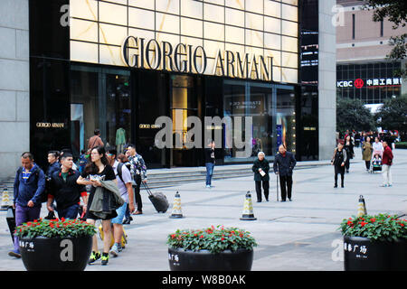 --FILE--Pedestrians walk past a Giorgio Armani store in Chongqing, China, 23 November 2015.    Italian fashion house Giorgio Armani experienced a slow Stock Photo