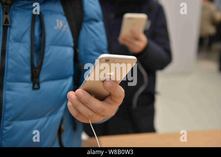 --FILE--A customer tries out an iPhone 6S Plus smartphone at an Apple Store in Shenyang city, northeast China's Liaoning province, 9 January 2016.   A Stock Photo