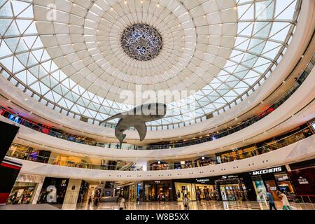 People walk past stores in the Wanda Mall at the Nanchang Wanda Cultural Tourism City in Nanchang city, east China's Jiangxi province, 27 May 2016. Stock Photo