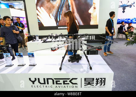 Visitors look at UAVs (unmanned aerial vehicles), or drones, of Yuneec during the 2016 International Consumer Electronics Show Asia (CES Asia 2016) in Stock Photo