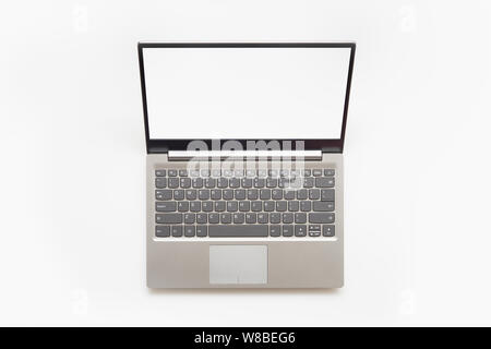 Top view of Open modern laptop with English keyboard and copy space blank screen, isolated on white background. Stock Photo