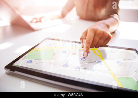 Close-up Of A Person's Hand Using GPS Service On Digital Laptop Stock Photo