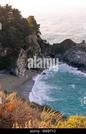 Warm morning light washing over McWay Falls along the Big Sur coastline in California. Stock Photo
