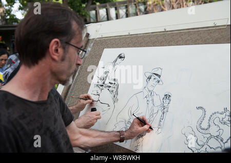 A foreign cartoonist draws pictures showing their impressions of Beijing during the 'Drawing Beijing - World Artists Illustrate Beijing' event at Shic Stock Photo