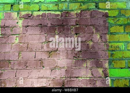 Old painted brick wall brown and green colors close up. Abstract background Stock Photo