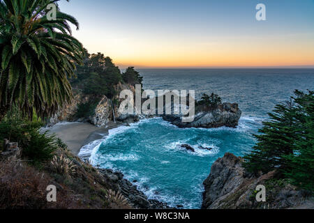 Wide view of the waterfall at McWay Falls pouring on to the sandy beach in California. Stock Photo