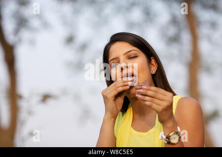 Young woman eating chocolate bar Stock Photo