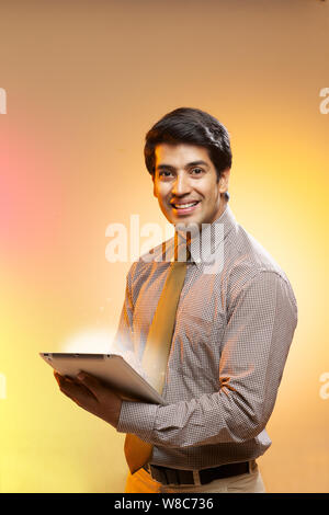 Businessman using a digital tablet and lights streaming from it Stock Photo