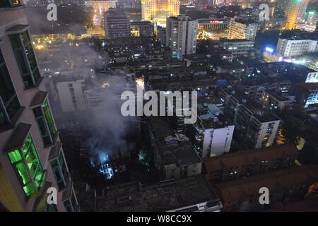 Smoke rises from the debris of a burnt-out old apartment building  at a residential quarter in Chengdu city, southwest China's Sichuan province, 28 Ju Stock Photo
