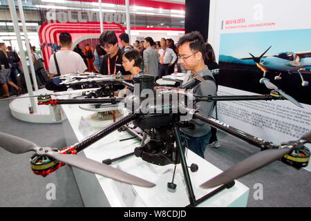 --FILE--Visitors look at unmanned aerial vehicles (UAV) or drones on display at the stand of Yuneec International Co. Ltd. during the 2015 Internation Stock Photo