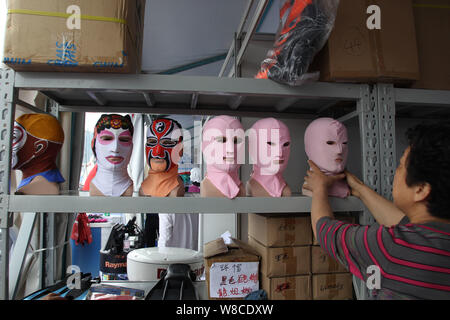 Chinese facekini designer Zhang Shifan puts Peking Opera and other facekini masks on display at her stand during the 13th China International Marine F Stock Photo