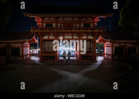Kyoto, Japan - April 2, 2019: Young couple enters the gate of Yasaka Shrine at night Stock Photo