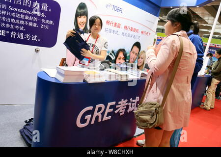 --FILE--People visit the booth of ETS (Education Testing Service) to get information about TOEFL (Test of English as a Foreign Language) and GRE (Grad Stock Photo