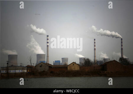 --FILE--Smoke and steam are discharged from chimneys and cooling towers at a coal-fired power plant in Jinan city, east China's Shandong province, 18 Stock Photo