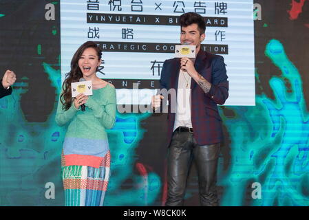 American singer Adam Lambert, right, speaks as Chinese singer Zhang Liangying laughs during a press conference for the strategic cooperation between B Stock Photo