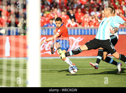 Chile's Alexis Sanchez, left, shoots against Argentina during the Copa America 2015 final soccer match between Chile and Argentina at the National Sta Stock Photo