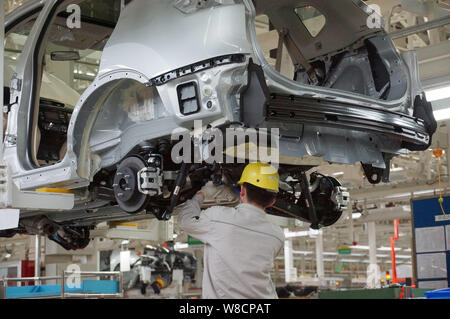 --FILE--A Chinese worker assembles a car on the assembly line at an ...