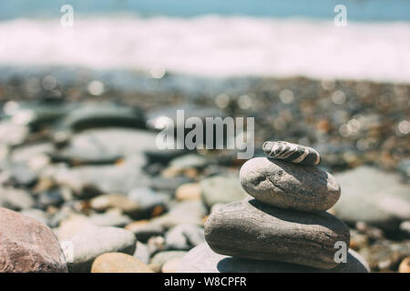 Pile of pebbles stones on the blurred sea beach background Stock Photo