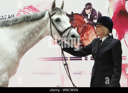 British etiquette expert Diana Mather poses with a horse at an equestrian exhibition at CITIC Pacific Plaza ahead of the 2015 Shanghai Longines Global Stock Photo