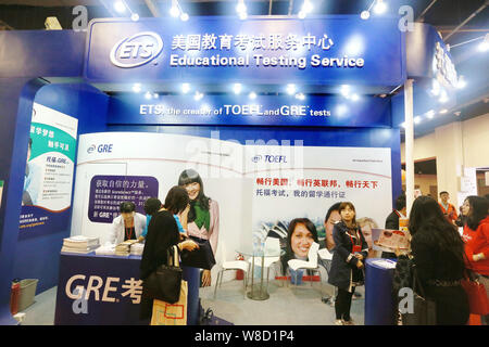 --FILE--People visit the booth of ETS (Education Testing Service) to get information about TOEFL (Test of English as a Foreign Language) and GRE (Grad Stock Photo