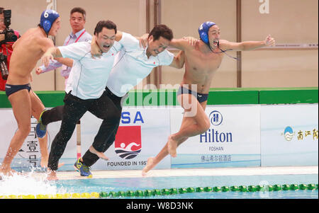 Coaches and players of Japan men's national water polo team celebrate after defeating China men's national water polo team during the 2015 Asian Water Stock Photo