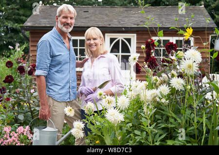 Portrait Of Mature Couple Working In Flower Beds In Garden At Home Stock Photo