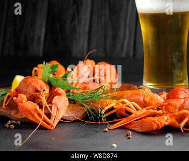 lobsters with beer lemon lime and dry pepper on black background Stock Photo