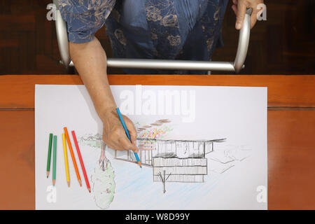 Elderly woman painting color on her drawing  , hobby at home Stock Photo