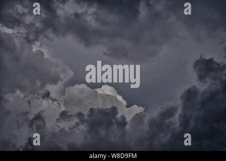 Dark gray and black gloomy rain clouds in the sky, storm, hurricane. Spectacular picture Stock Photo
