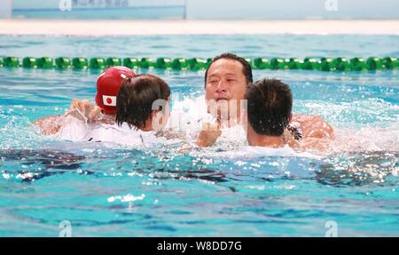 Coaches and players of Japan men's national water polo team celebrate after defeating China men's national water polo team during the 2015 Asian Water Stock Photo