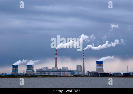 --FILE--Smoke and steam are discharged from chimneys and cooling towers at a coal-fired power plant in Daqing city, northeast China's Heilongjiang pro Stock Photo