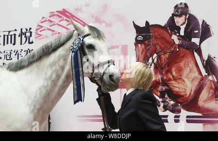 British etiquette expert Diana Mather kisses a horse at an equestrian exhibition at CITIC Pacific Plaza ahead of the 2015 Shanghai Longines Global Cha Stock Photo