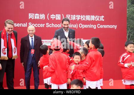 Retired French football player Robert Pires, back center, interacts with children during the opening ceremony of the Arsenal Soccer School (China) in Stock Photo
