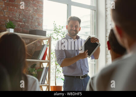Male speaker giving presentation in hall at university workshop. Audience or conference hall. Student asking a question, teacher giving an answer. Scientific conference event, training. Education. Stock Photo