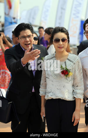 Kenneth Fok Kai-kong, eldest son of Hong Kong tycoon Timothy Fok Tsun-Ting, left, and his wife, Chinese Olympic diving champion Guo Jingjing, pose dur Stock Photo