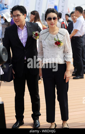 Kenneth Fok Kai-kong, eldest son of Hong Kong tycoon Timothy Fok Tsun-Ting, left, and his wife, Chinese Olympic diving champion Guo Jingjing, pose dur Stock Photo