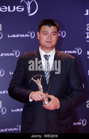 --FILE--Retired Chinese basketball star Yao Ming poses with his trophy of Spirit of Sport Award after the award ceremony for the Laureus World Sports Stock Photo