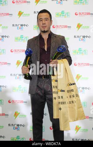 Chinese singer Yang Kun poses with his trophies during the 22th Oriental Billboard Awards ceremony in Shanghai, China, 30 March 2015. Stock Photo