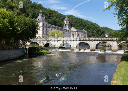 Brantome en Perigord, France. The Pont Coude (Right Angle Bridge) over the River Dronne, with the Abbey of Brantome in the background. Stock Photo