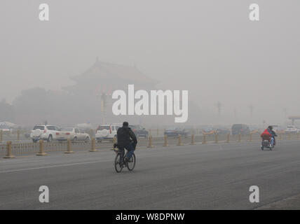 Cyclists and cars pass by Tiananmen Square in heavy smog in Beijing, China, 30 November 2015.   Beijing was again engulfed in heavy smog on Monday (30 Stock Photo