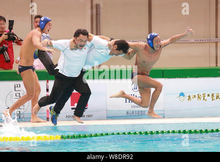 Coaches and players of Japan men's national water polo team celebrate after defeating China men's national water polo team during the 2015 Asian Water Stock Photo