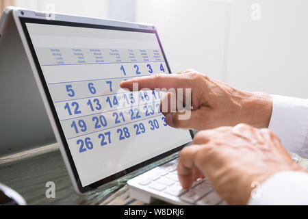 Businessman Looking At Calendar With Daily Agenda Stock Photo