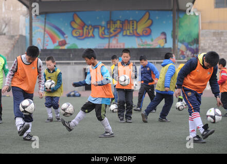 --FILE--Chinese students practise football skills during a training session at Dicun Primary School in Taiyuan city, north China's Shanxi province, 17 Stock Photo